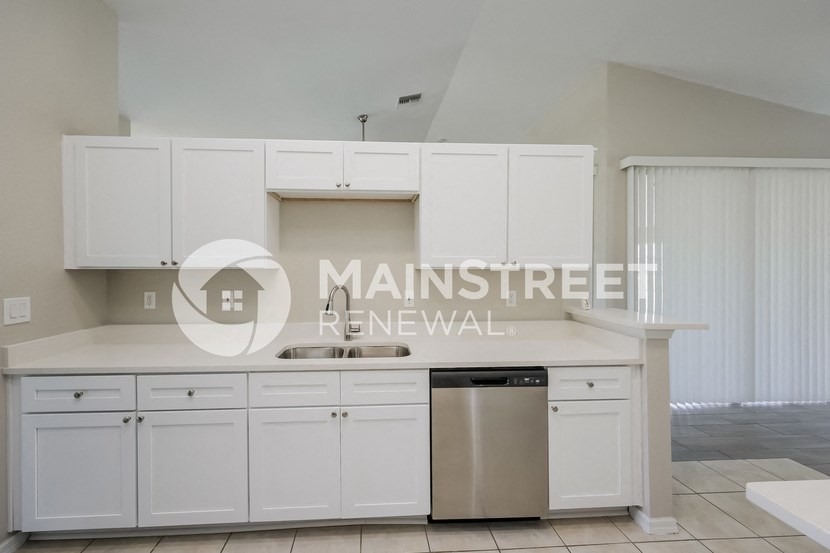 a renovated kitchen with white cabinets and stainless steel appliances