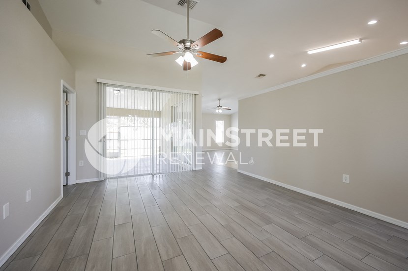 a living room with hardwood floors and a ceiling fan