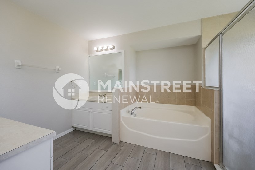 a renovated bathroom with a bath tub and a closet