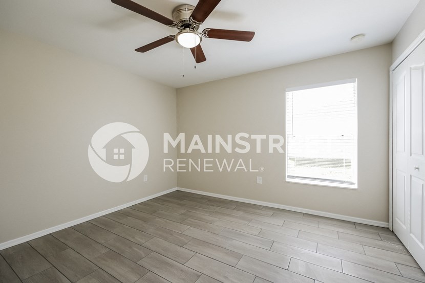 a living room with a ceiling fan and a window