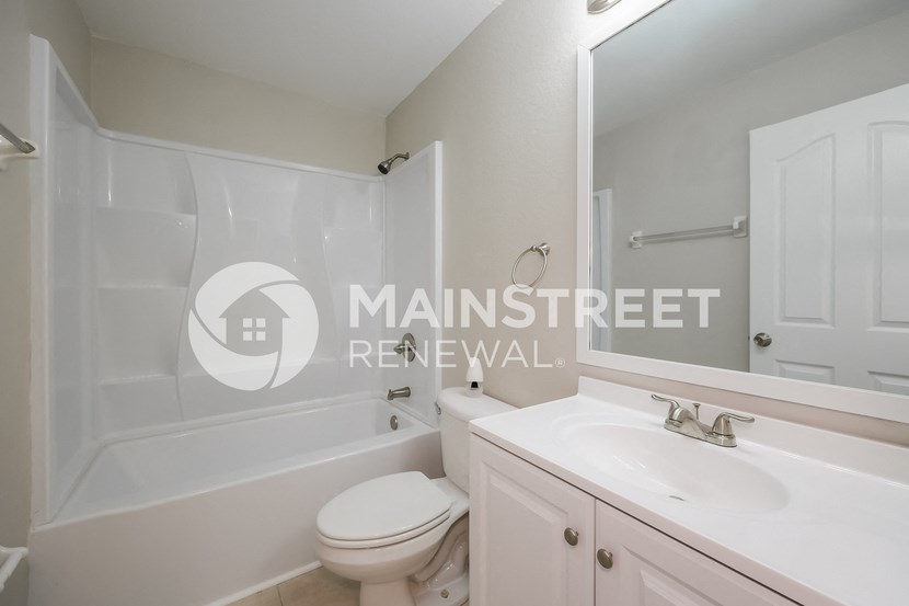 a white bathroom with a sink and a toilet