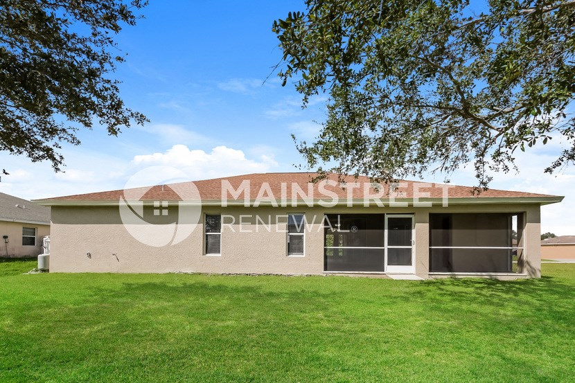 a building with a lawn and a tree in front of it