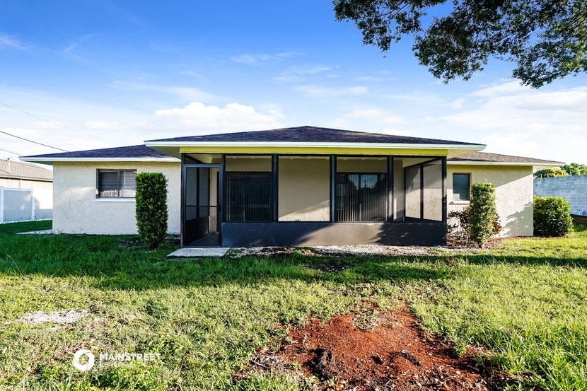 a small house with a yard and a body of water