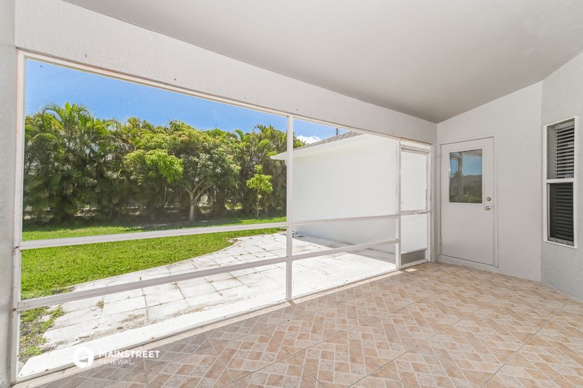 a balcony with a view of a yard and a door