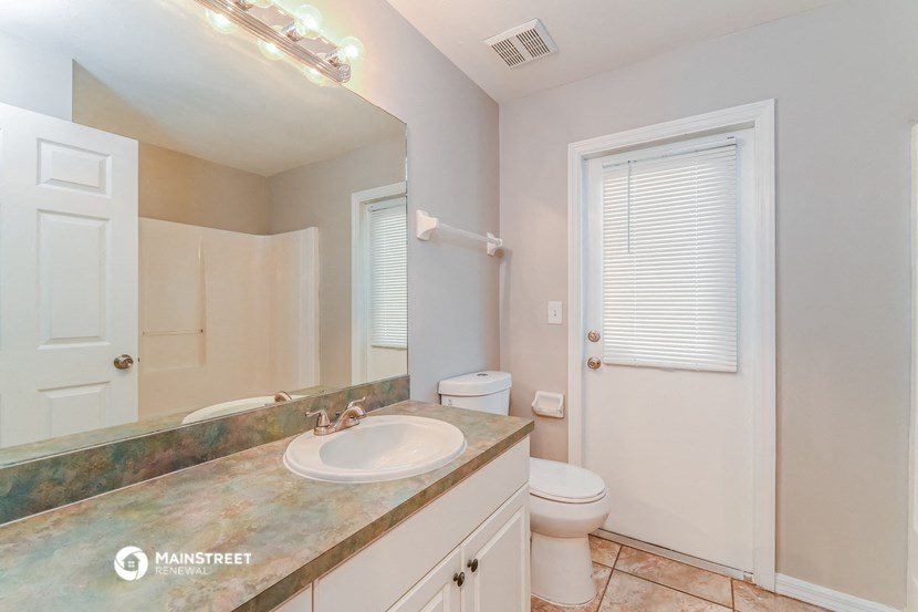 a bathroom with a sink and a toilet and a mirror