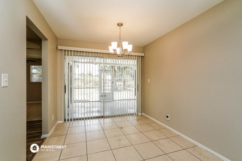 an empty living room with a sliding glass door to a patio