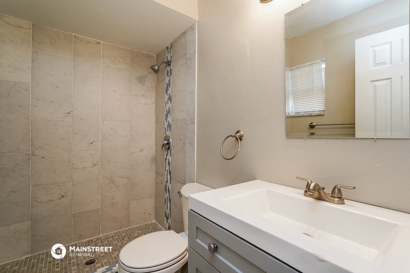 a bathroom with a sink and a toilet and a shower