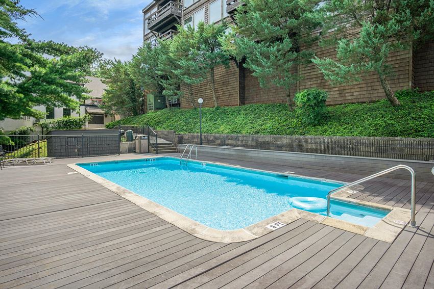 a swimming pool on a wooden deck next to a building