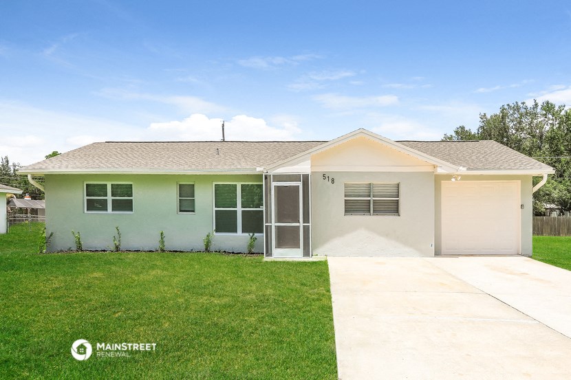 a white house with a lawn and a garage door