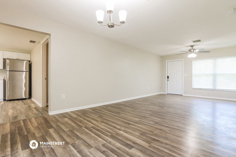 the spacious living room and dining room with wood flooring
