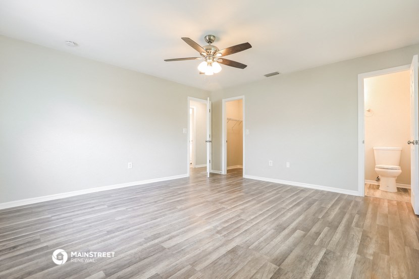 the living room of an empty house with a ceiling fan