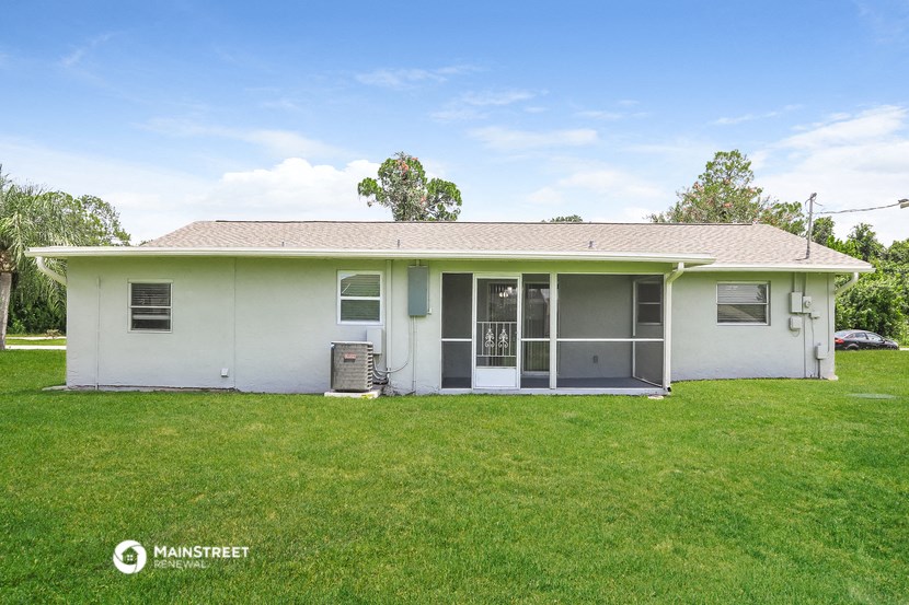a small white house with a grassy yard