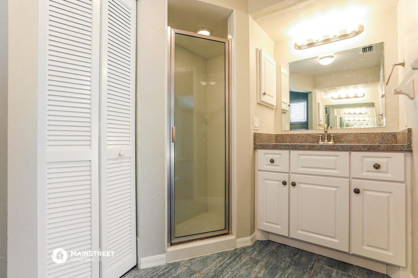 a bathroom with a shower and a sink and a mirror