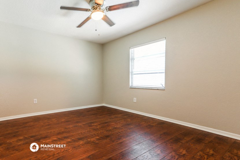 the bedroom with hardwood floors and a ceiling fan