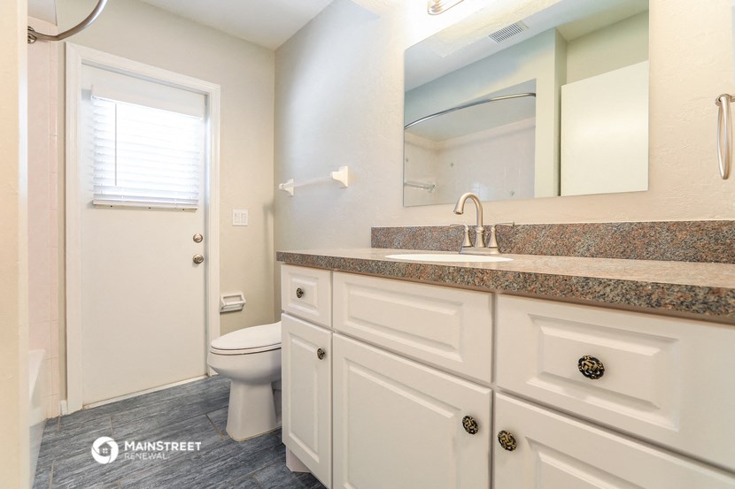 a bathroom with white cabinets and a sink and a toilet
