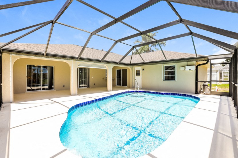 a swimming pool in front of a house with a glass roof