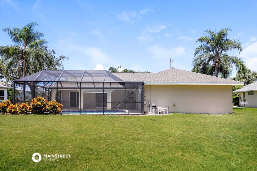 a house with a screened porch and a pool in the yard