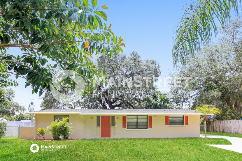 a small house with a yard and a tree