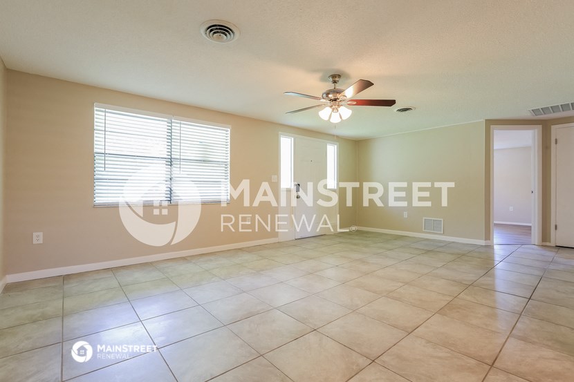 a large living room with tile floors and a ceiling fan