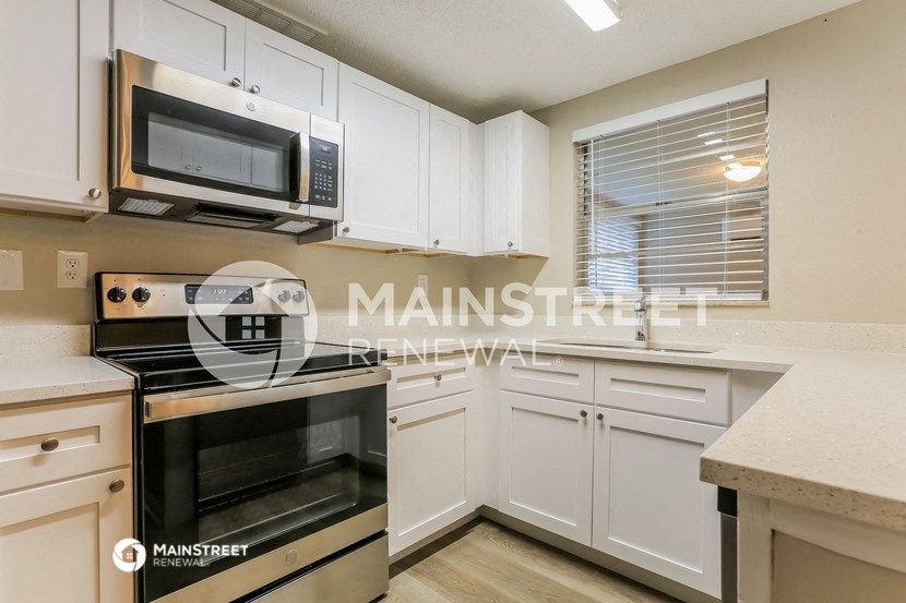 a kitchen with white cabinets and stainless steel appliances