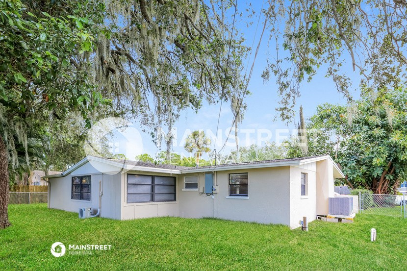 a small white house with a tree in the yard