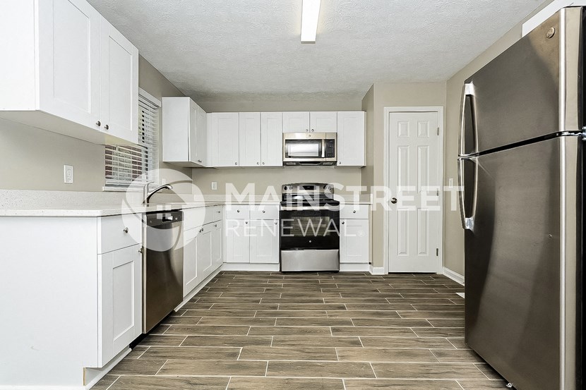 a white kitchen with stainless steel appliances and white cabinets