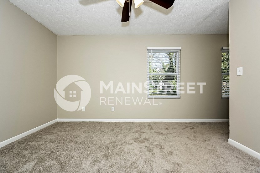 an empty living room with carpet and a window