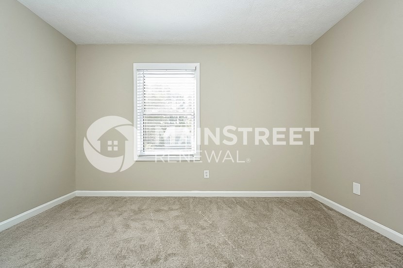 an empty room with carpet and a window