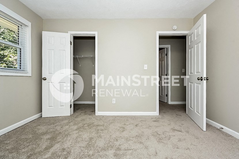 an empty room with two doors and a closet