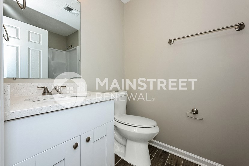 a bathroom with a toilet and a sink and a mirror