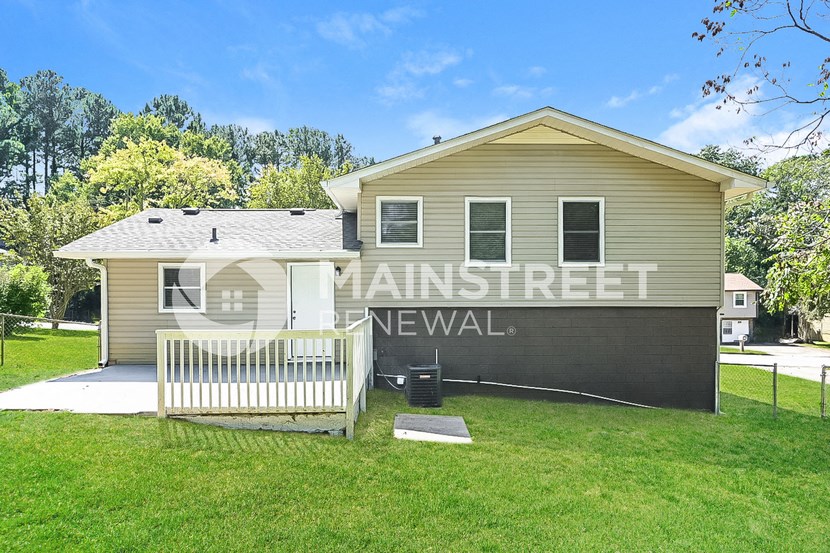 a small house with a yard and a white fence