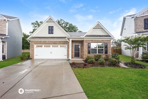 a brick house with a white garage door and a driveway