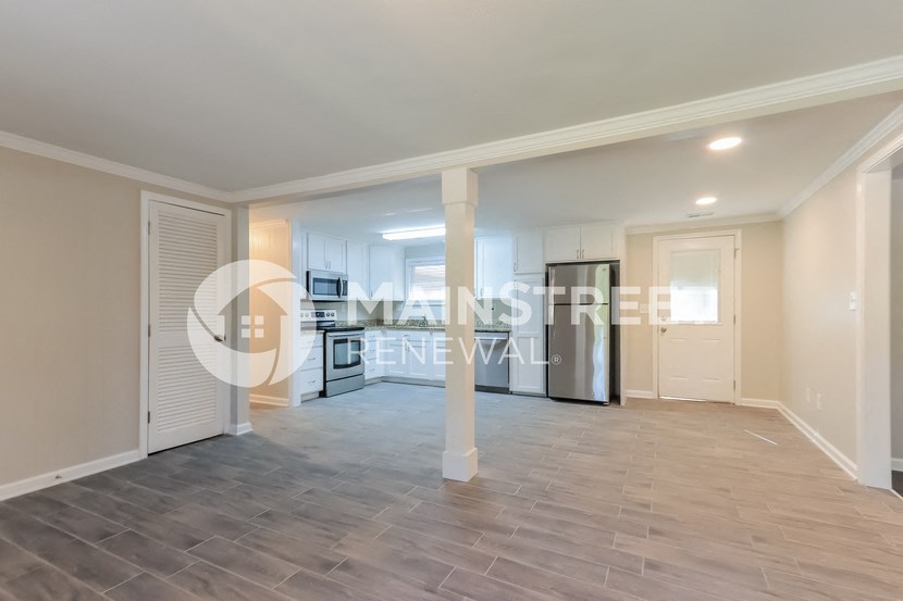 a renovated living room with a large open floor plan and a kitchen