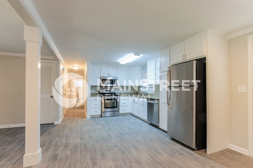 a kitchen with white cabinets and a stainless steel refrigerator