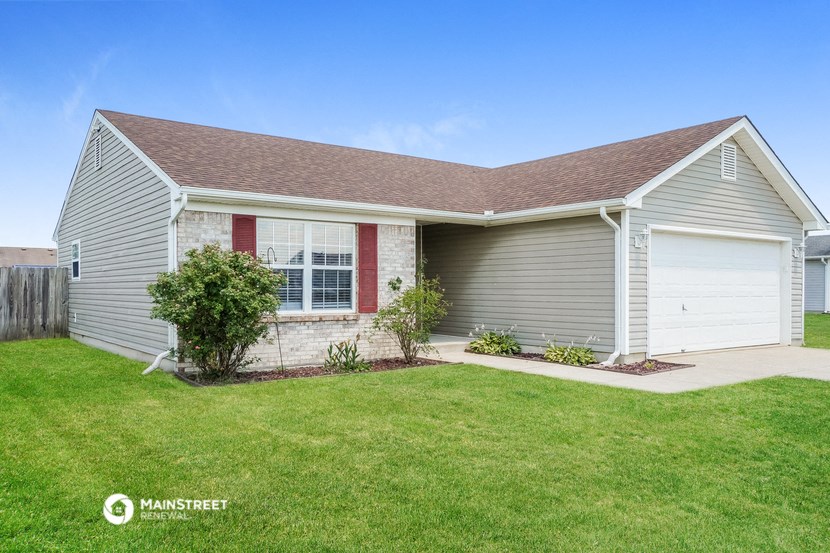 a gray house with a lawn and a white garage door