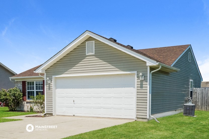 a garage with a white door in front of a house