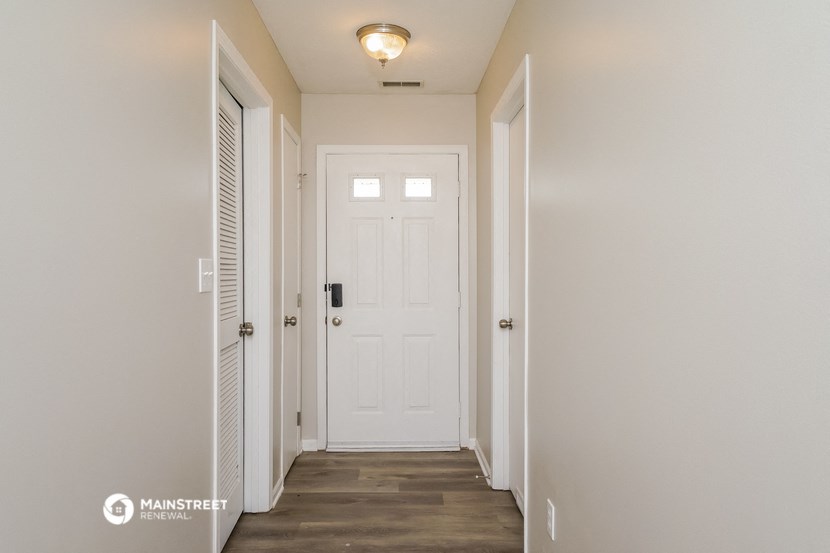 the hallway of a home with a white door