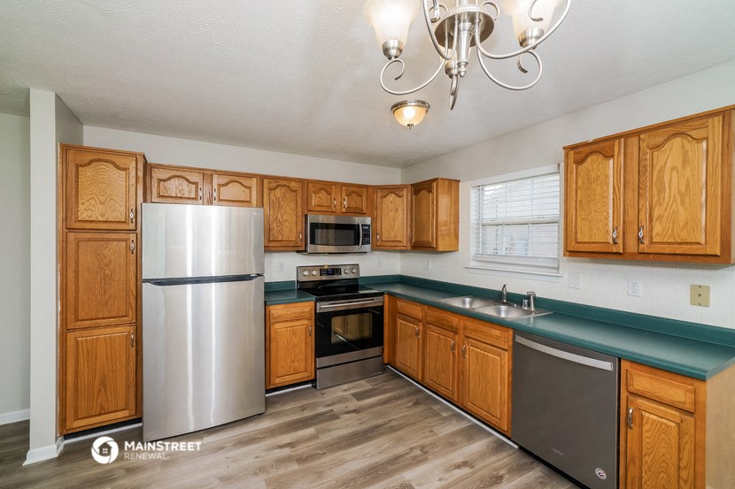 a kitchen with wooden cabinets and stainless steel appliances