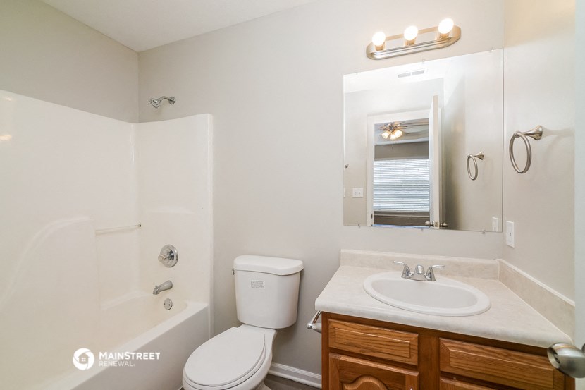 a bathroom with a sink toilet and shower and a mirror
