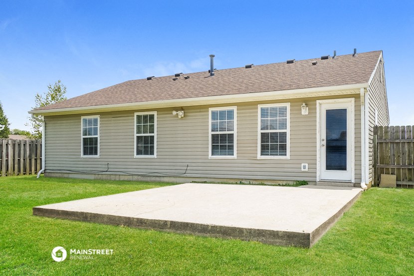 a tan house with a concrete patio in front of it
