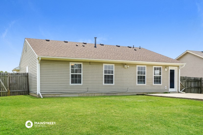 the front of a house with a yard and a fence