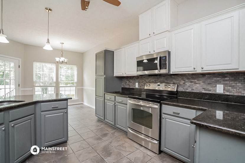 a kitchen with gray and white cabinets and stainless steel appliances