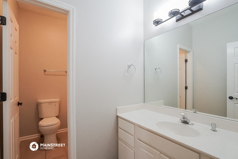 a bathroom with a mirror and a sink and a toilet