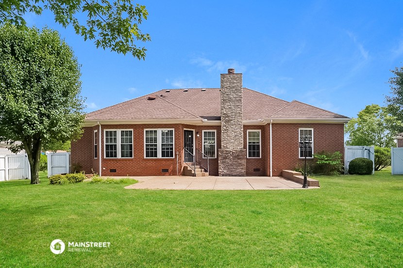a brick house with a lawn and a stone chimney