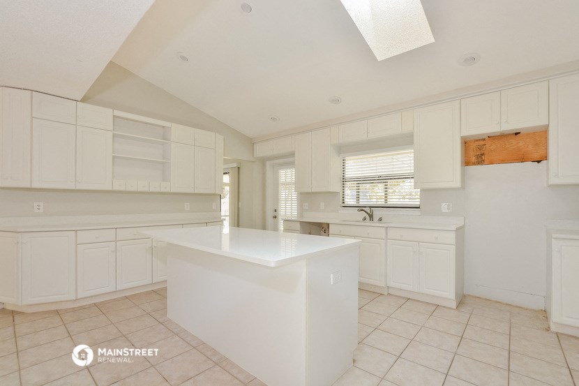 a large kitchen with white cabinets and a white counter top