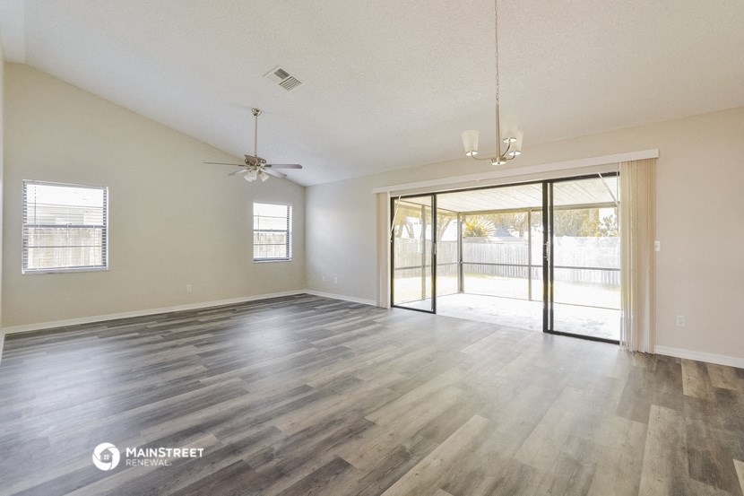 an empty living room with wood flooring and sliding glass doors