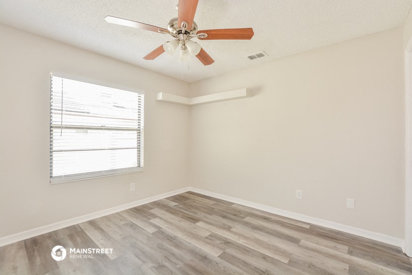 a living room with a ceiling fan and a window