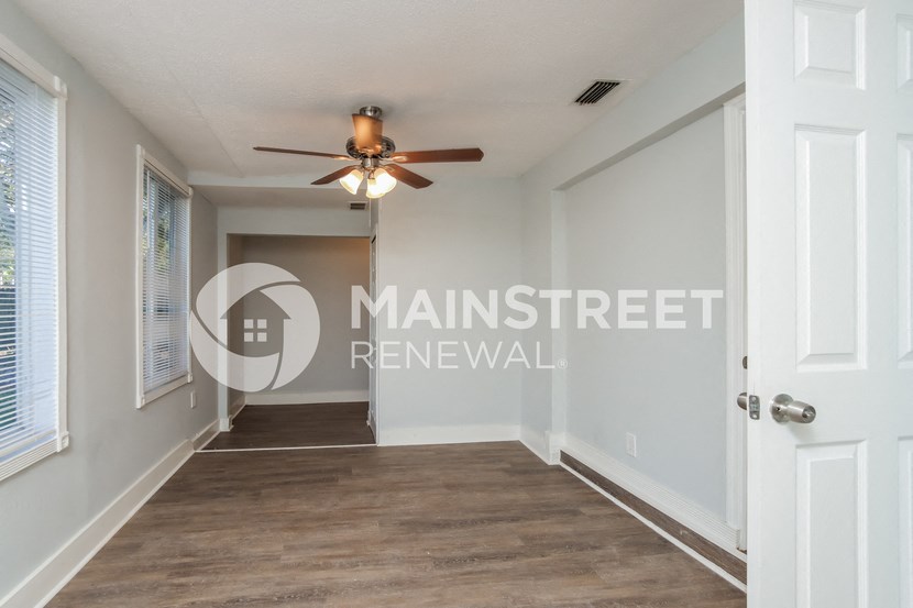 a hallway with a ceiling fan and a door to a closet