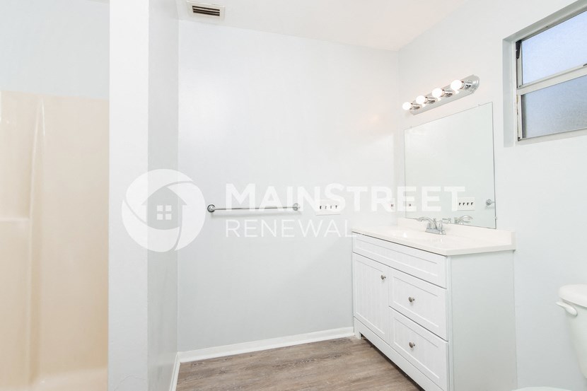 a white bathroom with a sink and a mirror