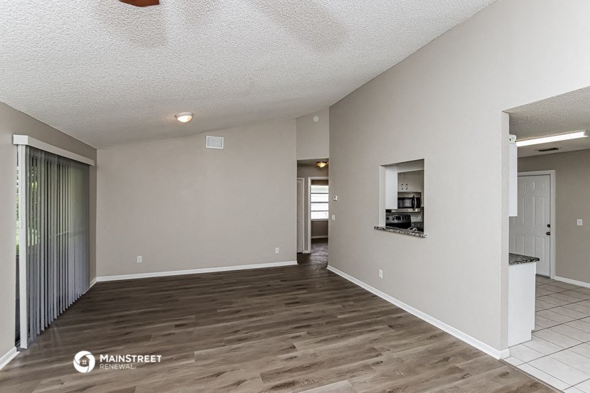 the living room and dining room of a manufactured home with wood flooring